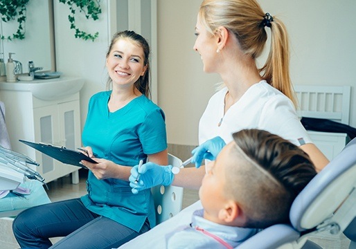 Two smiling team members and dental patient